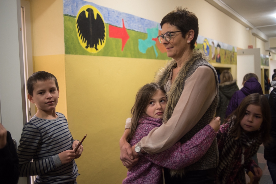 Gabriela Thomas, director of the elementary school in Golzow gives a student a hug between classes in the main hallway. Thomas says that the children of the refugee families are already fitting into her school very well. Gabriela Thomas, director of the elementary school in Golzow gives a student a hug between classes in the main hallway. Thomas says that the children of the refugee families are already fitting into her school very well.